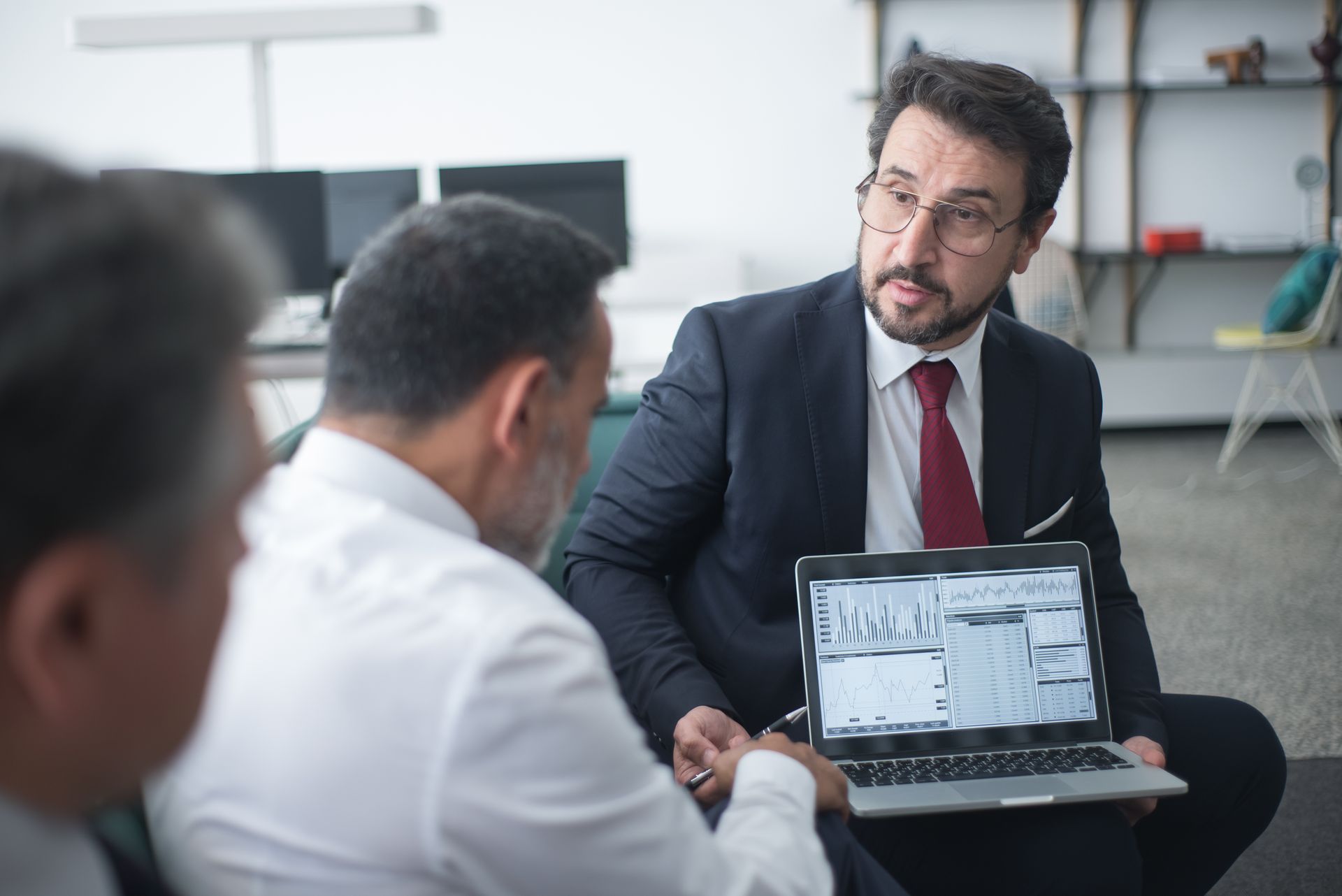 Consultant discussing with a team around a laptop